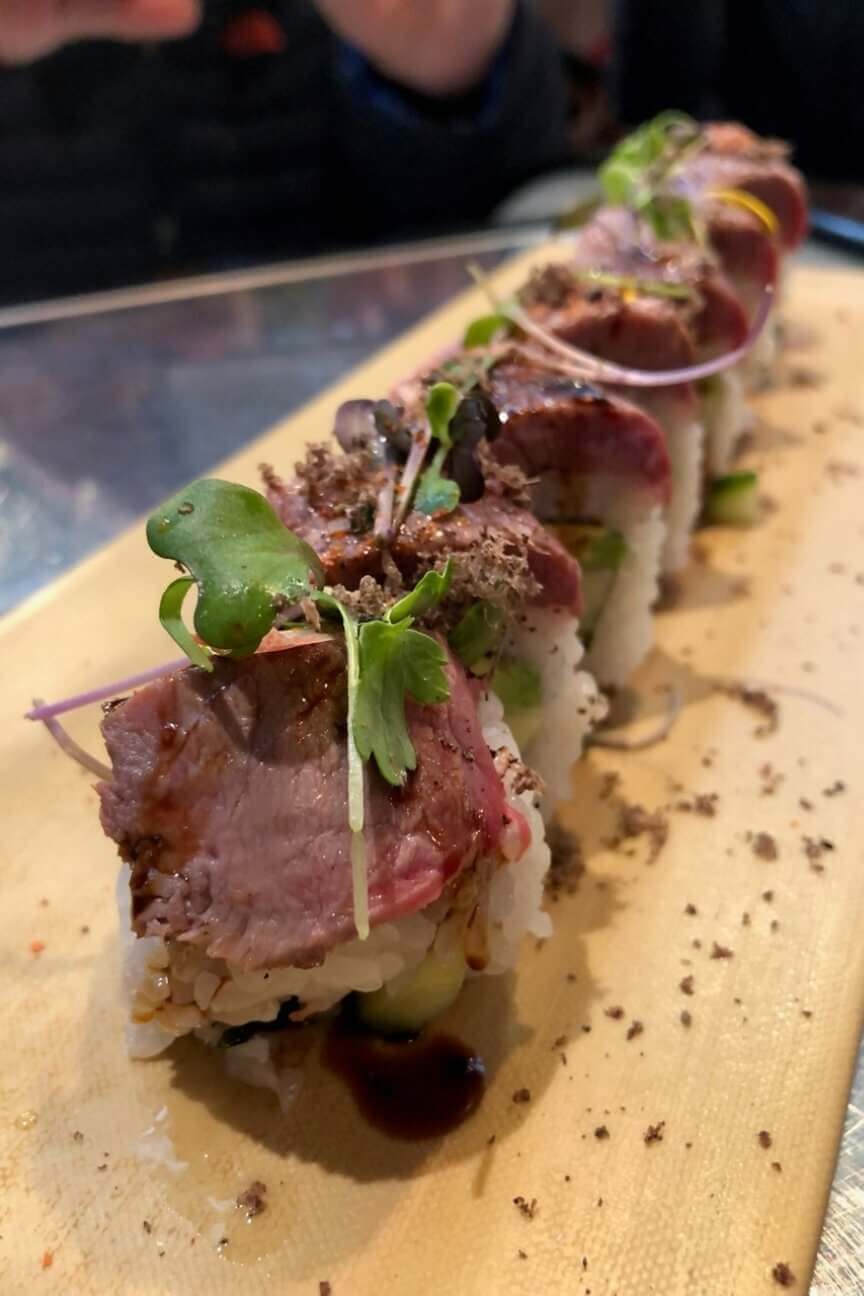 Surf & Turf Truffle Roll: Snow Crab, Avocado, Cucumber, Topped with Seared Akaushi Filet, Micro Greens, Soy Balsamic Reduction & Grated Fresh Truffle